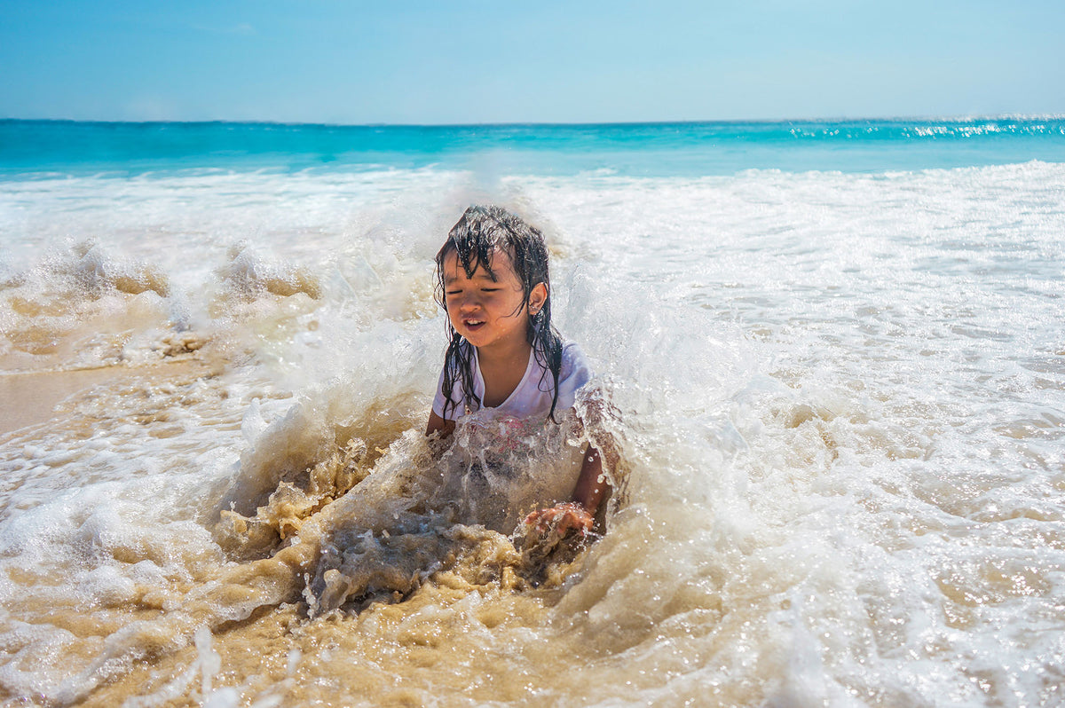 Child playing in the water on the beach